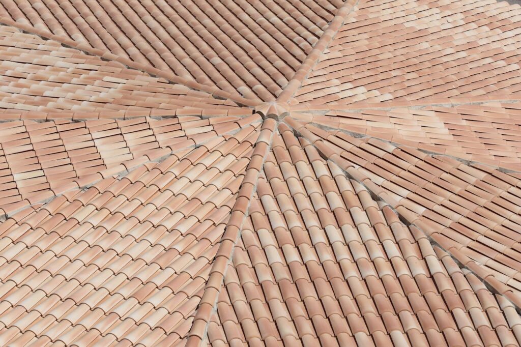Detailed view of terracotta roof shingles forming a geometric pattern from above.